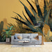 Black and gold mural wallpaper featuring desert cactus with elegant golden accents on dark background for modern living room decor
